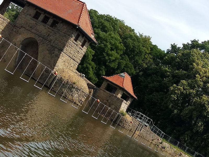 Blick vom Wasser auf altertümliche Brücke